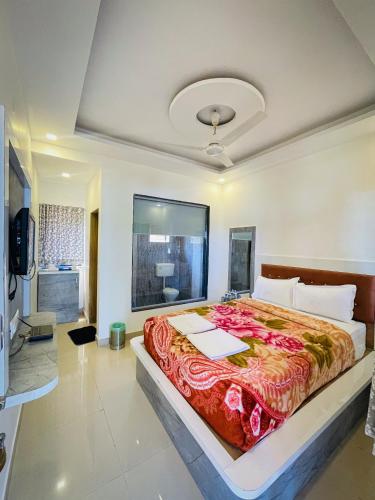 ein Schlafzimmer mit einem großen Bett mit einer roten Decke in der Unterkunft Hill Side Heaven Residency in Mahabaleshwar