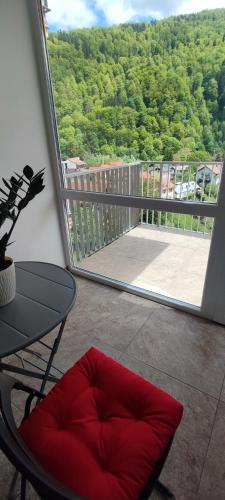 a balcony with a table and a chair and a window at STUDIO JACUZZI BELLE VIEW SINAIA-free parking in Sinaia