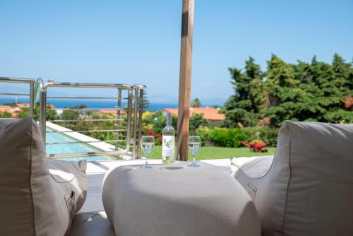 a table with two wine glasses on top of it at Horizon Villa-Private Pool-7 Bedroom-Gym-Sea View in Psalidi