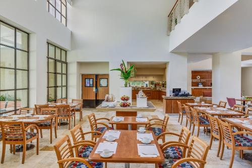a dining room with wooden tables and chairs at Fiesta Inn Colima in Colima