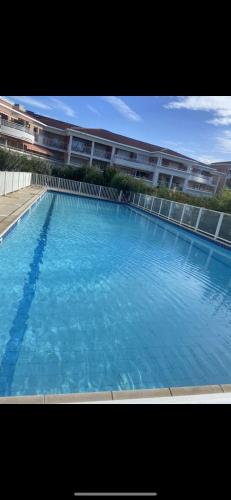 une grande piscine bleue devant un immeuble dans l'établissement 2pieces vue lac, au Cannet