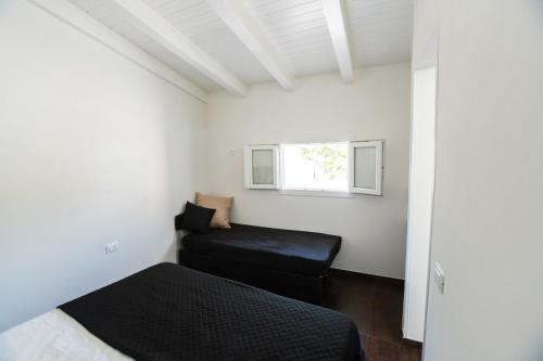 a small bedroom with a bed and a window at Villa Angel Lampedusa. in Lampedusa