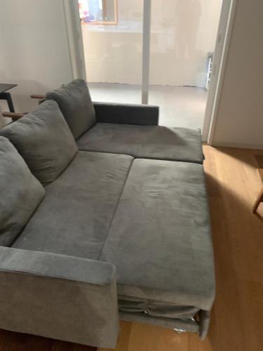 ein graues Sofa im Wohnzimmer in der Unterkunft 貸し切りゲストハウスsai2nd in Yasugi