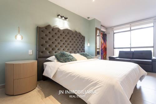 a bedroom with a large bed and a chair at Park 42 APARTASUITES in Medellín