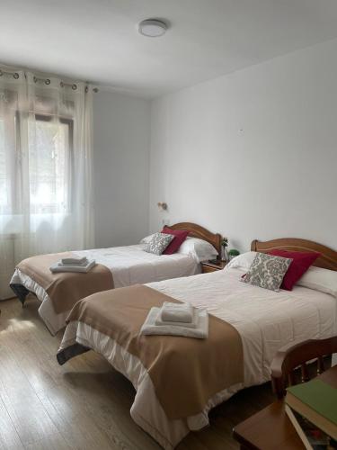 1 dormitorio con 2 camas y toallas. en Casa rural Gerardo en Armallones