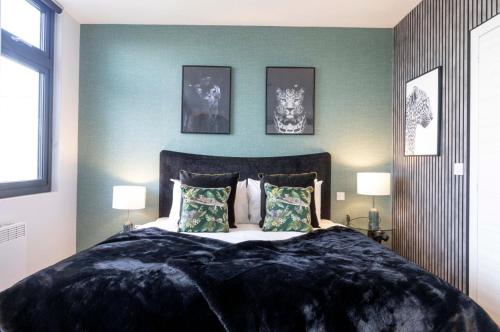 a bedroom with a large bed with two lamps at Palm Tree House - Panther in Orpington