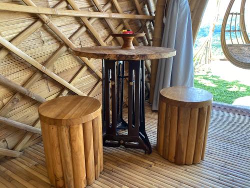a wooden table and two stools in a room at Gladak di Uma Bali in Sidemen