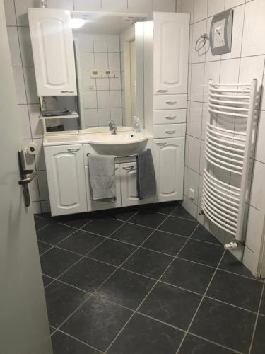 a white bathroom with a sink and a mirror at Ferien-Monteur-Wohnung am Bach im Grünen mit 3 Schlafzimmer in Hemer