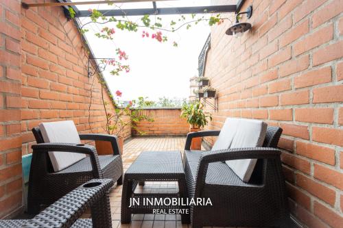 a patio with chairs and a table and a brick wall at Park 42 APARTASUITES in Medellín