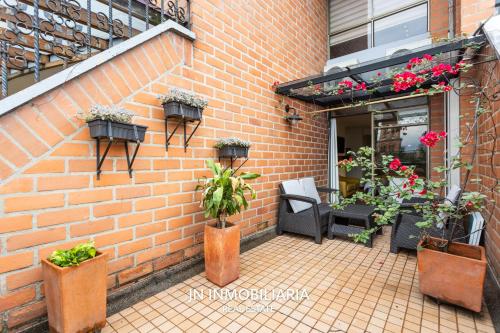 a brick wall with potted plants on a patio at Park 42 APARTASUITES in Medellín