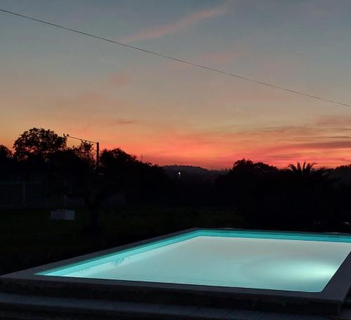 una piscina con puesta de sol en el fondo en Casa Alegria - Vista da Serra, 