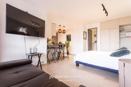 a living room with a bed and a kitchen at Park 42 APARTASUITES in Medellín