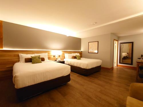 pokój hotelowy z 2 łóżkami i kanapą w obiekcie Timberland Inn w mieście Kenora