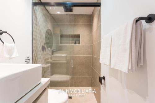 a bathroom with a shower and a sink and a toilet at Park 42 APARTASUITES in Medellín
