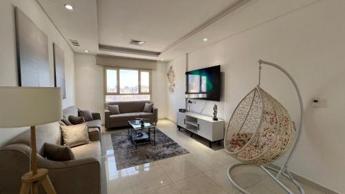 ein Wohnzimmer mit Sofa und Schaukel in der Unterkunft Luxurious apartment in Mahboula in Kuwait