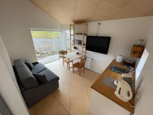 - un salon avec un canapé et une table dans l'établissement Peaceful Lakeside Cabin, à Reynivellir