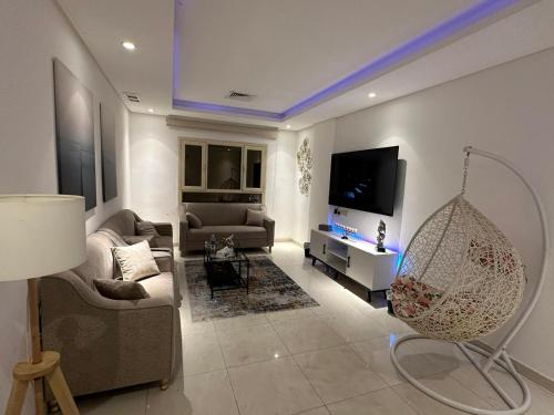 ein Wohnzimmer mit einem Sofa und einem TV in der Unterkunft Luxurious apartment in Mahboula in Kuwait