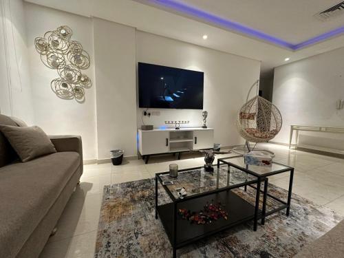 sala de estar con sofá y TV en Luxurious apartment in Mahboula, en Kuwait