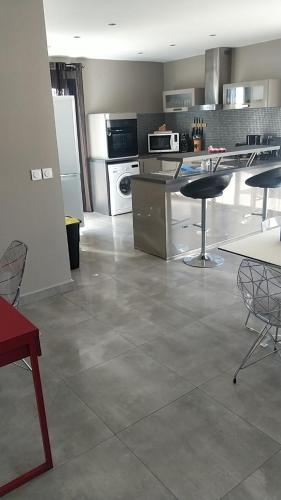 une cuisine avec une table, des chaises et un comptoir dans l'établissement gite des masques, à Mireval