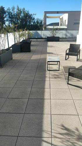 - une terrasse avec 2 bancs au-dessus d'un bâtiment dans l'établissement gite des masques, à Mireval