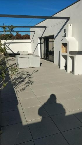 une ombre d'une personne prenant une photo d'une maison dans l'établissement gite des masques, à Mireval