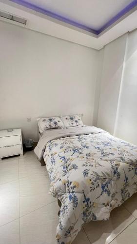 1 Schlafzimmer mit einem Bett mit Blumenbettdecke in der Unterkunft Luxurious apartment in Mahboula in Kuwait