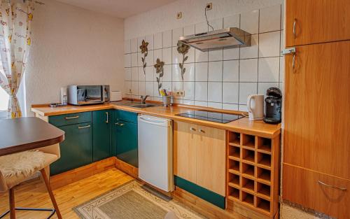 een keuken met groene kasten en een witte koelkast bij Wohnen über einem mediterranen Restaurant,Apartment 2 oder 3 in Leipzig