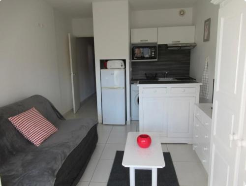 un salon avec un canapé et une balle rouge sur une table dans l'établissement Appartement Sanary Sur Mer., à Sanary-sur-Mer