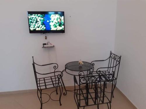 Hay Salam agadir only for family في أغادير: طاولة وكراسي مع تلفزيون على الحائط