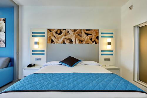 a bedroom with a blue bed with two night stands at Riu Dunamar - All Inclusive in Cancún