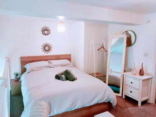 a bedroom with a bed with a mirror and a dresser at Butterfly Apartment in Ossett