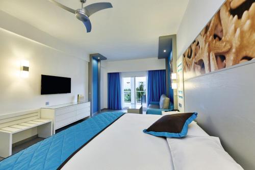 a bedroom with a large bed and a television at Riu Dunamar - All Inclusive in Cancún