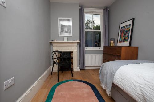 - une chambre avec un lit, une cheminée et une fenêtre dans l'établissement 2 Bed Apartment in Sydenham, London, à Forest Hill