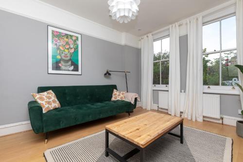 a living room with a green couch and a coffee table at 2 Bed Apartment in Sydenham, London in Forest Hill