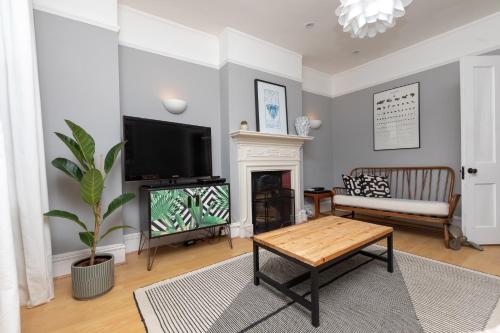 a living room with a fireplace and a tv at 2 Bed Apartment in Sydenham, London in Forest Hill