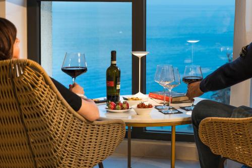 a group of people sitting at a table with wine glasses at Belduomo in Taormina