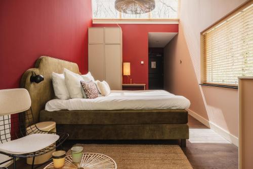 ein Schlafzimmer mit einem Bett und einer roten Wand in der Unterkunft Zoomers aan het Bos in Castricum