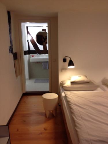a bedroom with a bed with a lamp and a door at Romantik Hotel Alte Vogtei in Hamm
