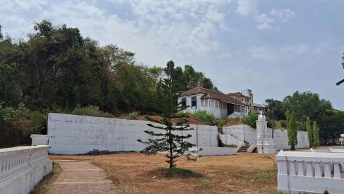una casa dietro una recinzione bianca con un albero in cortile di Halcyon - Tropical Elegance - 2BHK a Moira