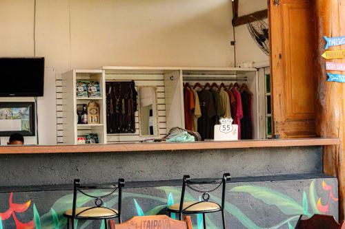 a store counter with two chairs in front at Hostel Caiçara Maresias in São Sebastião