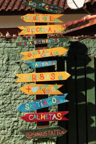 a group of signs on the side of a building at Hostel Caiçara Maresias in São Sebastião