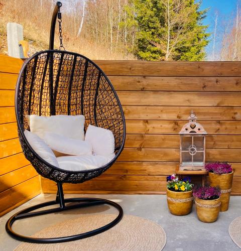 a swing chair on a patio with a fence at GÓRSKA CISZA - Duży, komfortowy, wyjątkowy Apartament in Stronie Śląskie