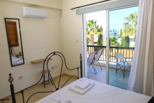 1 dormitorio con cama y vistas a un balcón en Sunset Green 01, en Pafos