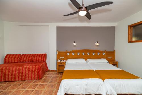 a bedroom with two beds and a ceiling fan at La Fragua II in Trevélez