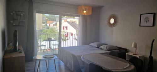 une chambre avec un lit et un balcon dans l'établissement Grand studio moderne hyper centre, à Pornichet