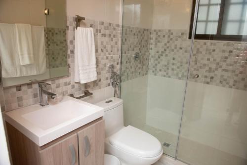 a bathroom with a toilet and a sink and a shower at CASA BIANCA Bella Vista in Panama City