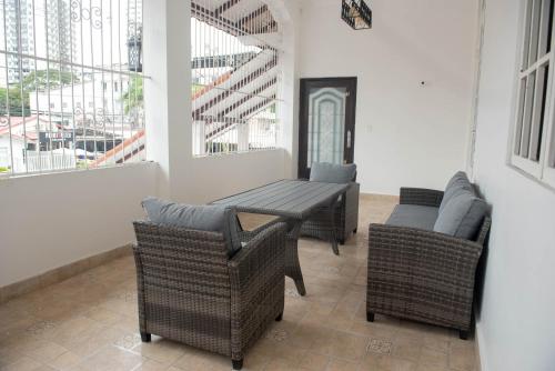 a patio with wicker chairs and a table and chairs at CASA BIANCA Bella Vista in Panama City