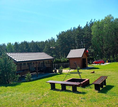 a park with a picnic table and a house at Leśne Zacisze domki letniskowe in Lipnica