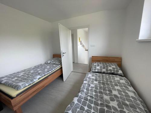 a bedroom with two beds and a door open at Apartmán Bystřice in Bystřice nad Pernštejnem