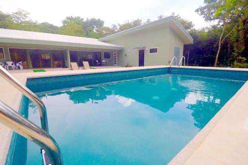 a swimming pool in front of a house at Casa Mari Black Stallion in Tamarindo
